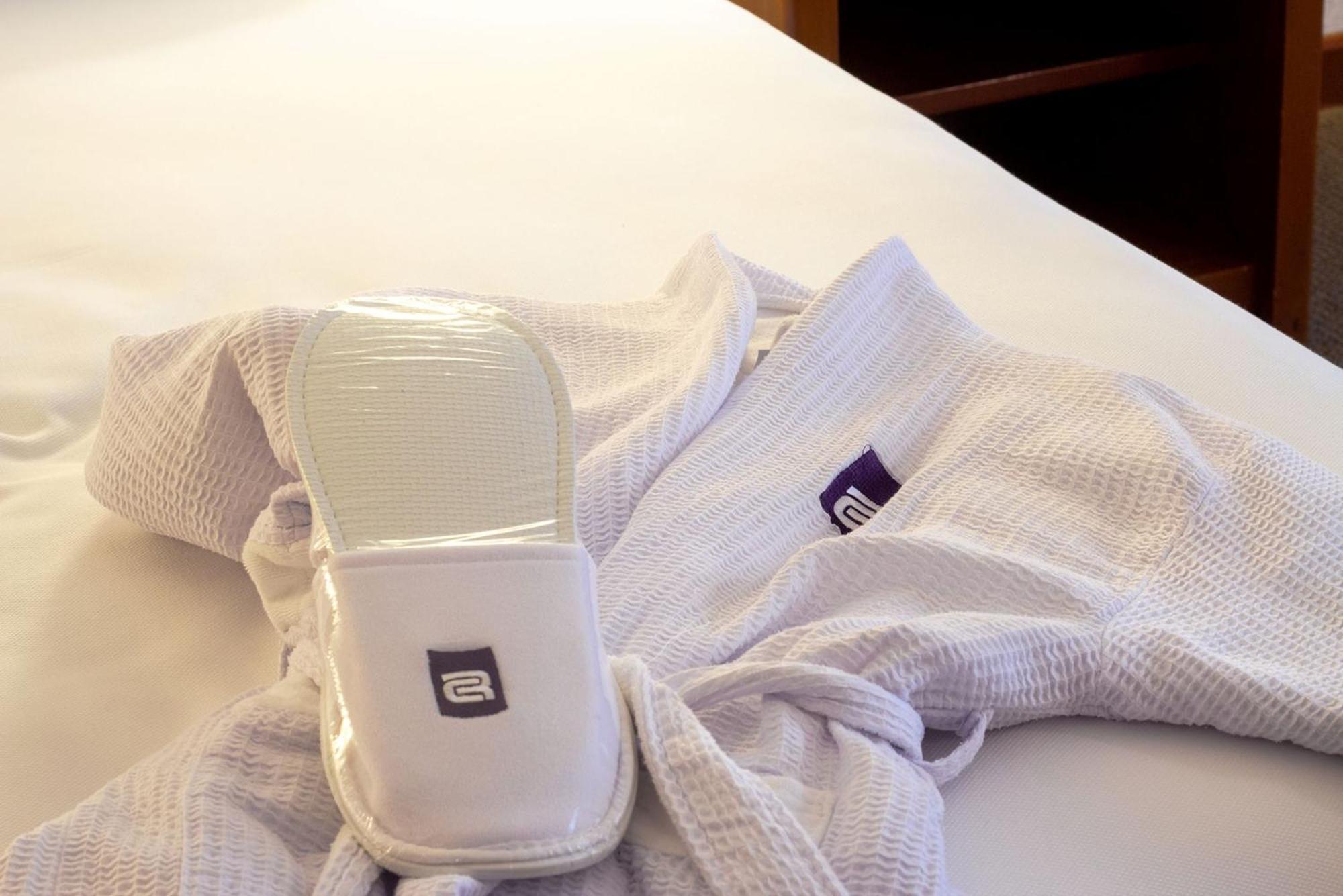 ホテル カミノ レアル グアダラハラ サポパン エクステリア 写真 A hotel guest room with a robe and slippers